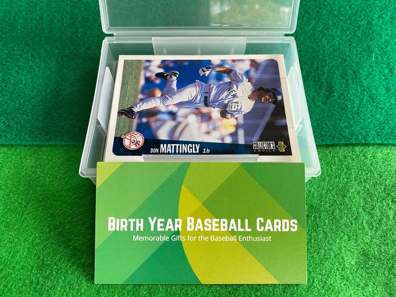 May include: A clear plastic storage box with a green background. The box contains baseball cards with a green, white, and yellow design. The text on the card reads "Don Mattingly 1b" and "Collector's Choice". The text on the front of the box reads "Birth Year Baseball Cards" and "Memorable Gifts for the Baseball Enthusiast".