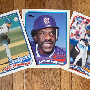 May include: Three baseball cards featuring players from the Dodgers, Cubs, and Mets. The Dodgers card features Orel Hershiser, the Cubs card features Andre Dawson, and the Mets card features Darryl Strawberry.