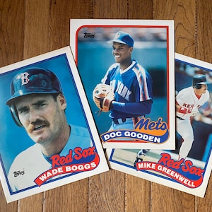 May include: Three baseball cards featuring players from the Red Sox and Mets. The cards are from the Topps brand. The cards feature Wade Boggs, Doc Gooden, and Mike Greenwell.