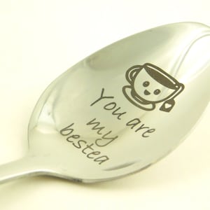 May include: A silver spoon with the words "You are my bestea" engraved on it. A cartoon teacup with a smiley face is also engraved on the spoon.