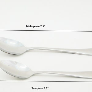 May include: Two silver spoons, one measuring 7.5 inches and labeled "Tablespoon" and the other measuring 6.5 inches and labeled "Teaspoon".