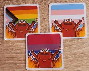 May include: Three square stickers featuring a red, orange, yellow, blue, and pink pride flag, a transgender pride flag, and a bisexual pride flag. Each sticker depicts a red cartoon character with arms raised in the air, surrounded by flames.