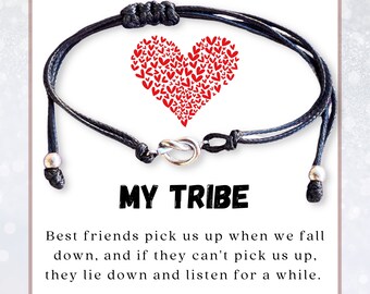 May include: Black friendship bracelet with a silver-colored knot clasp and two silver beads. The bracelet is on a white card with a red heart made of small hearts and the text "MY TRIBE". The card also includes a quote about friendship.