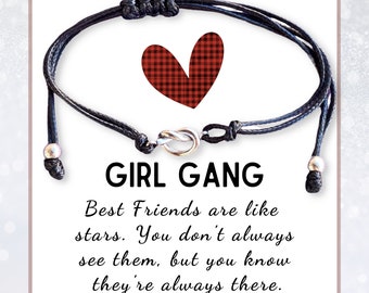 May include: Black friendship bracelet with a silver knot clasp. The card behind the bracelet has the words "GIRL GANG" and a red plaid heart. The text reads "Best Friends are like stars. You don't always see them, but you know they're always there."