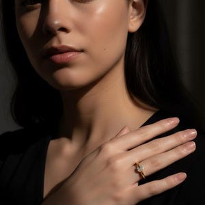 Puede incluir: Un anillo de oro con una piedra preciosa transparente de talla redonda en un engaste de garras. La banda es fina y pulida, con un acabado amarillo metálico. El anillo se lleva en el dedo, destacando el contraste entre el metal dorado y la piedra brillante.