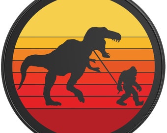 May include: A black and white silhouette of a Bigfoot walking a dinosaur on a leash against a sunset background with orange, red, and yellow stripes.