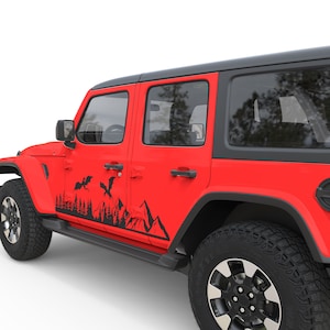 Puede incluir: Un Jeep Wrangler rojo con detalles negros y una calcoman&iacute;a negra de monta&ntilde;a y drag&oacute;n en el lateral. El Jeep est&aacute; estacionado sobre un fondo blanco.