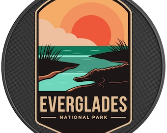 May include: A vintage-style patch with a sunset over a river and an alligator. The patch is beige with brown and green accents. The text "EVERGLADES NATIONAL PARK" is printed in brown on the patch.