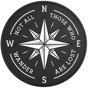 May include: Black and white compass with a white star in the center and the text "Not all those who wander are lost" around the edge.