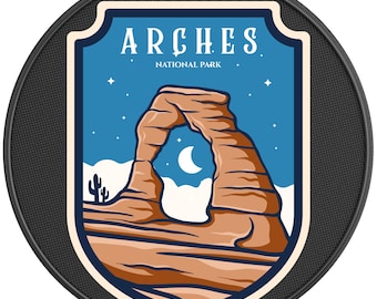 May include: A vintage-style patch with a blue background and a white border. The patch features a brown rock formation with a large archway, a crescent moon, and stars. The text "ARCHES NATIONAL PARK" is printed in white on a blue banner.