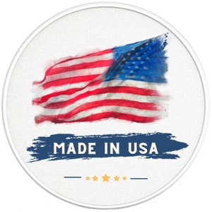 May include: A white circle with a red, white, and blue American flag in the center. The flag is painted in a watercolor style and is slightly faded. Below the flag is a blue and white brushstroke with the text "MADE IN USA" in white. There are five gold stars below the text.