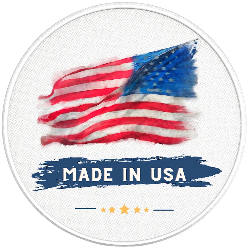 May include: A white circle with a red, white, and blue American flag in the center. The flag is painted in a watercolor style and is slightly faded. Below the flag is a blue and white brushstroke with the text "MADE IN USA" in white. There are five gold stars below the text.