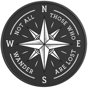 May include: Black and white compass with a white star in the center and the text "Not all those who wander are lost" around the edge.