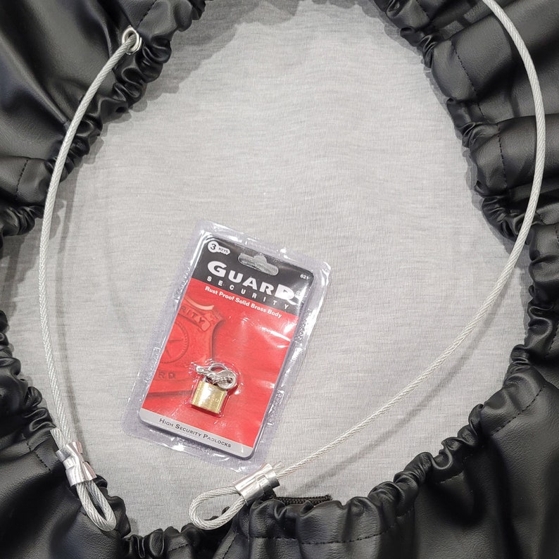 May include: A black leather bag with a silver cable and a brass padlock. The padlock is packaged in a clear plastic bag with a red and white label that reads "Guard Security Rust Proof Solid Brass Body High Security Padlocks".