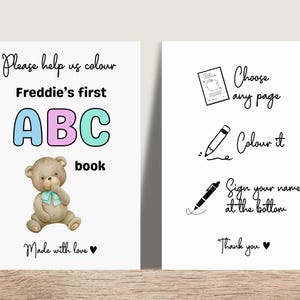 May include: A children's ABC book with a teddy bear illustration. The cover reads "Freddie's first ABC book" in colorful letters. Instructions on the right side say "Choose any page, Colour it, Sign your name at the bottom."