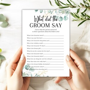 May include: A white bridal shower game card with the text "What did the GROOM SAY" in black script. The card features a list of questions for the groom to answer about the bride-to-be, with eucalyptus and gold accents.
