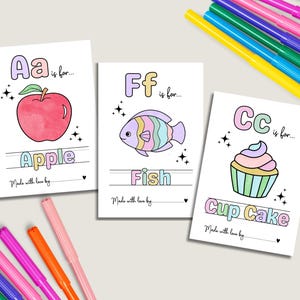 May include: Three illustrated cards with the letters A, F, and C, each paired with a corresponding image: an apple, a fish, and a cupcake. The cards are surrounded by colorful markers, perfect for coloring the illustrations.