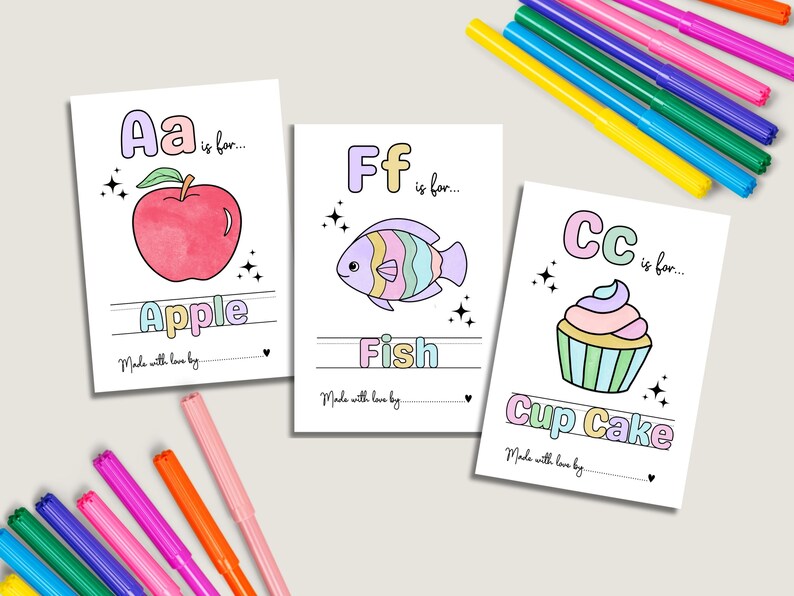 May include: Three illustrated cards with the letters A, F, and C, each paired with a corresponding image: an apple, a fish, and a cupcake. The cards are surrounded by colorful markers, perfect for coloring the illustrations.