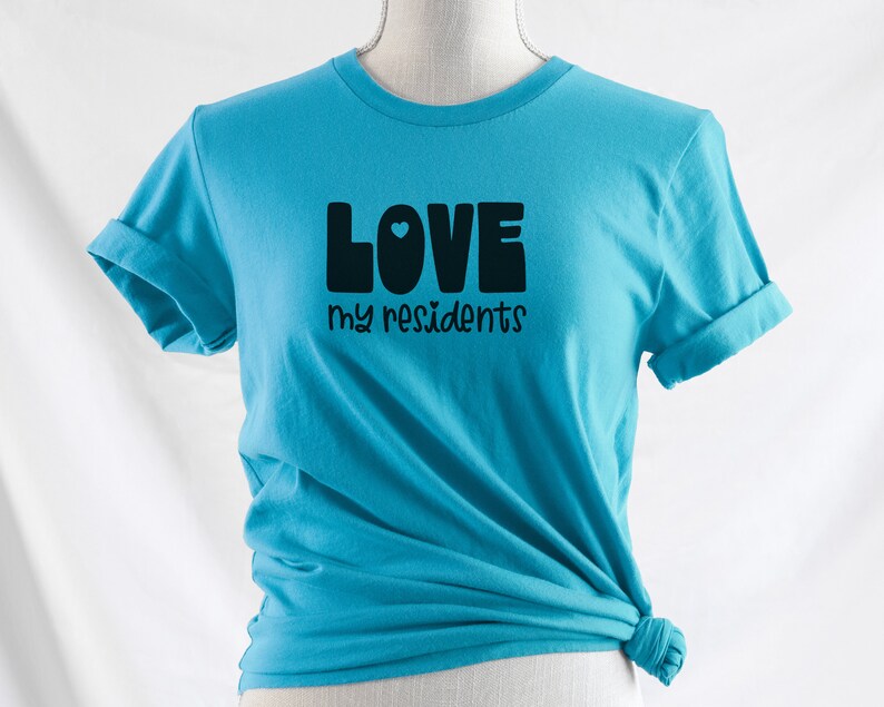 K&ouml;nnte beinhalten: Ein t&uuml;rkisfarbenes T-Shirt mit dem Text "LOVE my residents" in schwarzen Buchstaben mit einem kleinen blauen Herzen im "O".