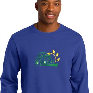 Pode incluir: Uma camisola azul real com um design bordado a verde e amarelo de um trator a puxar um caule de trigo.