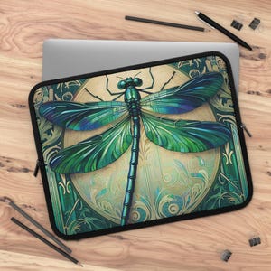 May include: A laptop sleeve featuring a green and blue dragonfly with intricate details on a gold and green background.