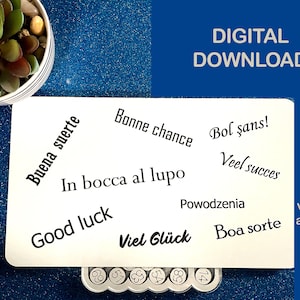 Puede incluir: Una tarjeta blanca con las palabras "Buena suerte" y otras frases en diferentes idiomas. Las palabras están en fuente negra. Las palabras "DESCARGA DIGITAL" están en fuente blanca. Una planta suculenta en una maceta a rayas blancas y negras está en la esquina superior izquierda.