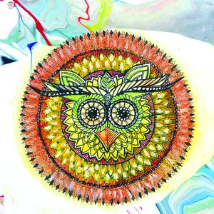May include: A colorful mandala with an owl in the center. The mandala is surrounded by a ring of orange petals. The owl has green feathers and large black eyes. The text "XIX Sun" is at the top of the image.