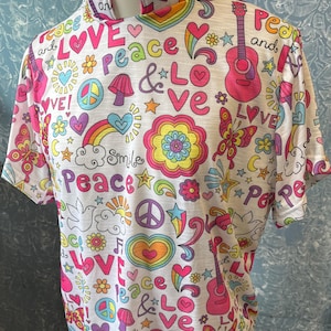 May include: White short-sleeved shirt with a high neck, covered in colorful graphics. The design includes the words "Peace" and "Love", along with rainbows, guitars, flowers, and butterflies. The shirt has a retro, hippie-inspired theme.