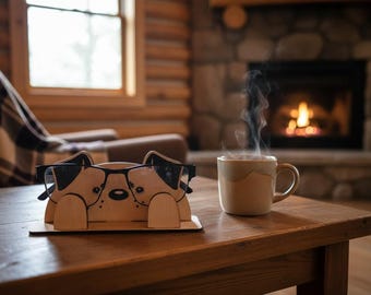Peut inclure: Un porte-lunettes en bois en forme de chien, avec des lunettes en place. Une tasse de café fumant est posée sur une table en bois. Une scène chaleureuse avec une cheminée en arrière-plan.