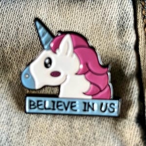 May include: A white unicorn with a pink mane and blue horn, with the text "Believe in us" on a blue banner below.