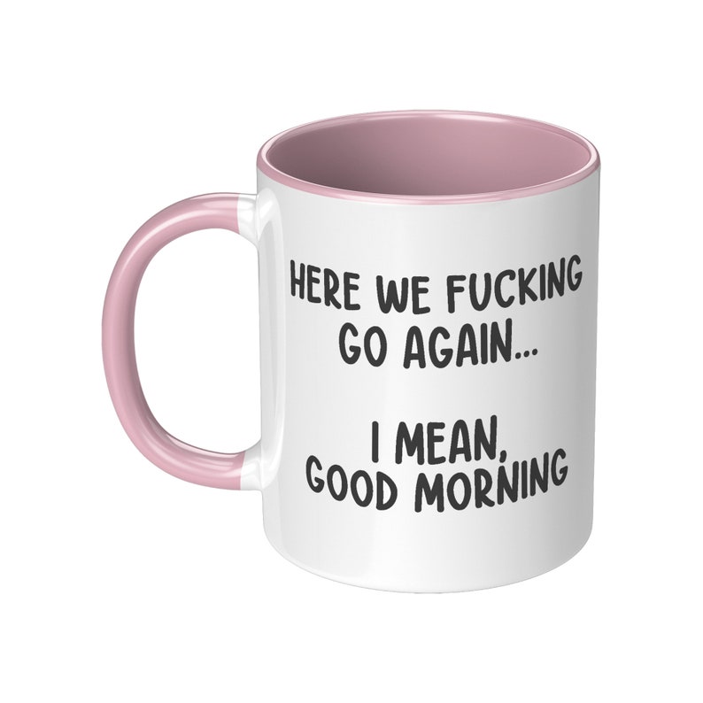 May include: White ceramic mug with a pink interior and handle. The mug features the text "HERE WE FUCKING GO AGAIN... I MEAN, GOOD MORNING" in black, bold font.