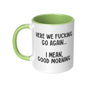 May include: White ceramic mug with a green interior and handle. The mug features the text "HERE WE FUCKING GO AGAIN... I MEAN, GOOD MORNING" in black, bold font.