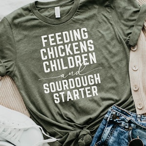 May include: A green t-shirt with the text "Feeding Chickens Children and Sourdough Starter" in white lettering.