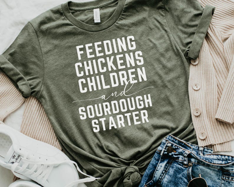 May include: A green t-shirt with the text "Feeding Chickens Children and Sourdough Starter" in white lettering.
