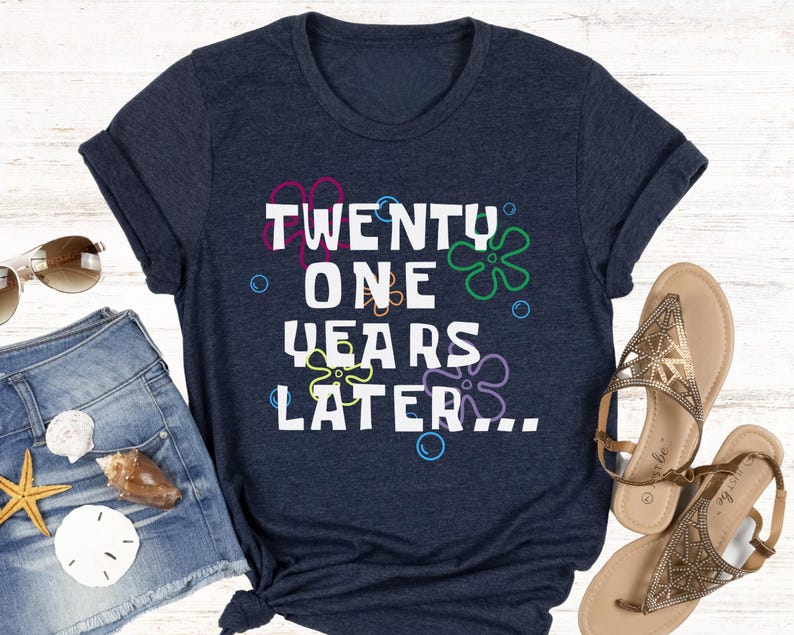 Navy blue 21st birthday t shirt flatlay featuring ‘21 years later’ text with playful floral bubble background design