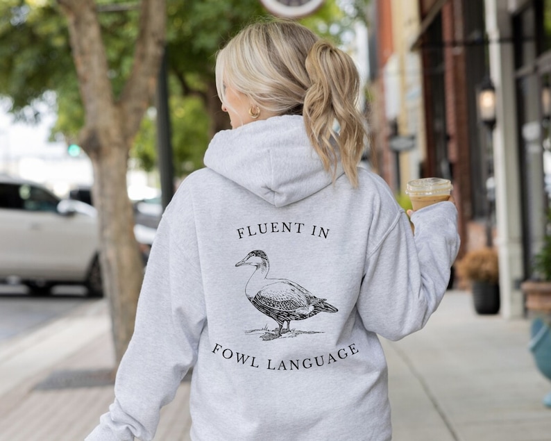 May include: A gray hooded sweatshirt with the text "Fluent in Fowl Language" and a black and white illustration of a duck on the back.