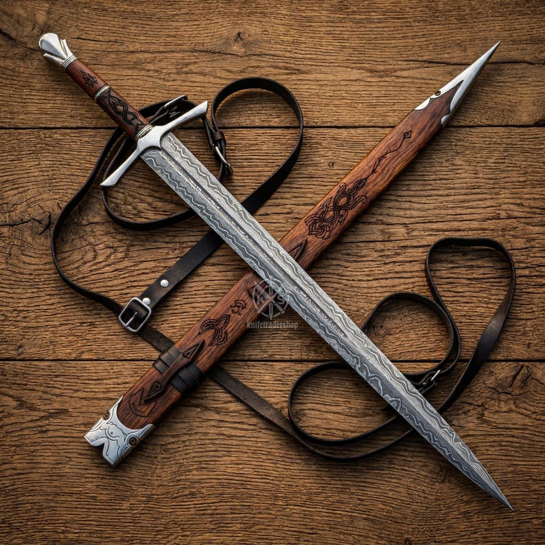 May include: A detailed image of a sword and scabbard. The sword features a patterned blade, a silver crossguard, and a dark wooden handle. The scabbard is made of wood with decorative carvings and a leather strap. The sword and scabbard are resting on a wooden surface.