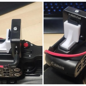 Może przedstawiać: Czarny rejestrator audio z białym plastikowym uchwytem przymocowanym do czarnego aparatu. Rejestrator audio ma czerwony przycisk i mały ekran z literą "O" na nim. Aparat ma czerwony przycisk i czarny uchwyt.