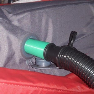 Peut inclure: Gros plan sur une valve d'air verte et noire sur un matelas gonflable rouge et gris.