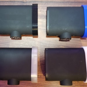 May include: Four black rectangular boxes with different colored trim. The boxes have a rounded edge on one side and a flat edge on the other. The trim colors are black, blue, white, and clear.