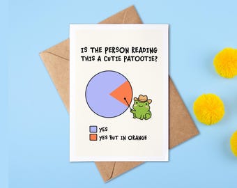 May include: A greeting card featuring a pie chart and a green frog wearing a brown cowboy hat. The text reads: IS THE PERSON READING THIS A CUTIE PATOOTIE? YES (blue square) and YES BUT IN ORANGE (orange square). The frog points to the orange slice.