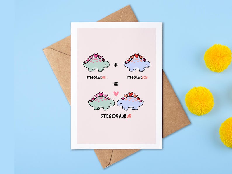 May include: A pink card with a cute illustration of two blue and green dinosaurs with hearts on their backs. The text on the card reads "Stegosaurus Me + Stegosaurus You = Stegosaurus Us".