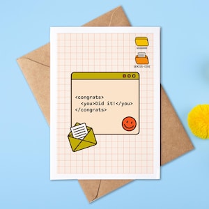 May include: A congratulations card with a computer-themed design. The card shows a computer window with the text "Congrats, you did it!" and a smiley face. The card is on a brown envelope, with yellow pom-poms on a blue background.