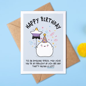 May include: A birthday card featuring a white ghost holding a purple, white and black star balloon. The card reads "Happy Birthday" and "To an amazing sprog. May your day be as fabulous as you are and that's saying a lot!"