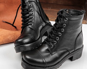 Könnte beinhalten: Zwei Paar schwarze Schnürstiefeletten aus Leder mit einem dicken Absatz und Reißverschlussdetail.
