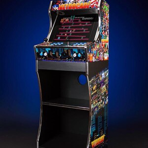May include: A black arcade cabinet with a retro video game design. The cabinet has a screen that displays a classic video game. The cabinet has a shelf on the bottom and a shelf on the side. The cabinet is decorated with a variety of video game characters.