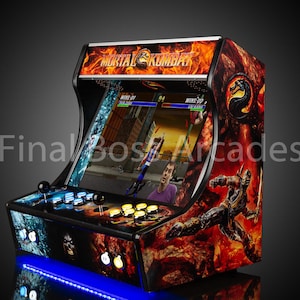 May include: A black arcade cabinet with a Mortal Kombat theme. The cabinet features a red and orange flame design with a black and silver Scorpion character on the side. The cabinet has a blue light underneath it.