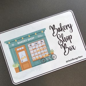 May include: A green and white sign with a cartoon illustration of a bakery shop. The sign says "Bakery Shop Box" and "@OwlAlwaysSave".