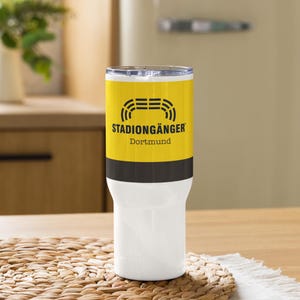 May include: A yellow and black stainless steel tumbler with the text "Stadiongänger Dortmund" printed on it. The tumbler has a black lid and a white base.