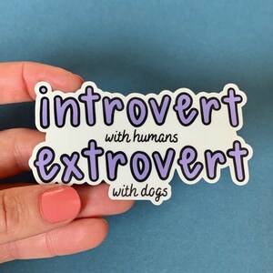 May include: A white sticker with purple text that reads "introvert with humans extrovert with dogs".